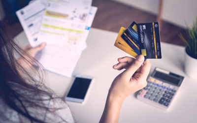 A lady checking multiple credit cards and her financial papers Image